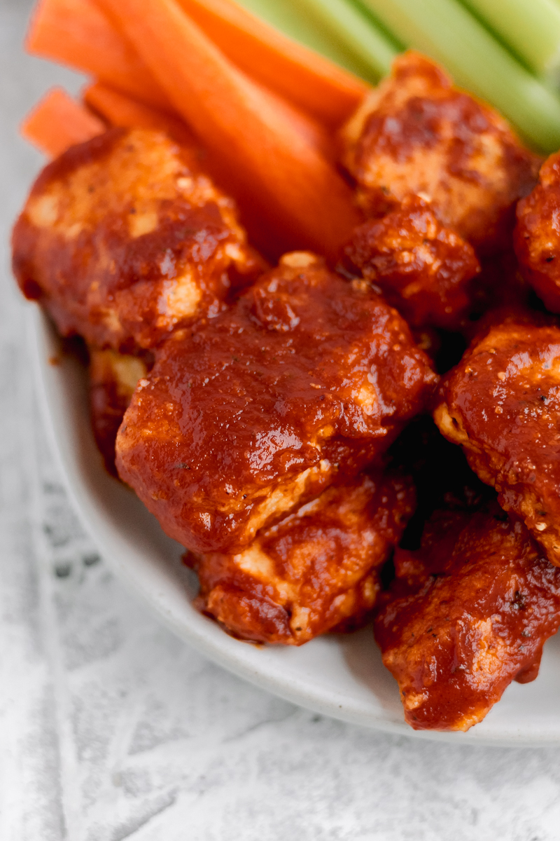 A plate with Whole30 BBQ Boneless Wings, celery, and carrots