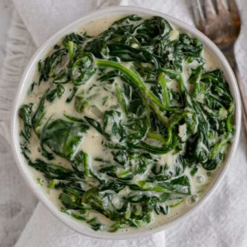 A white bowl filled with dairy free creamed spinach.