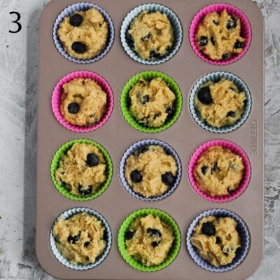 A muffin pan with each tin filled with muffin mixture