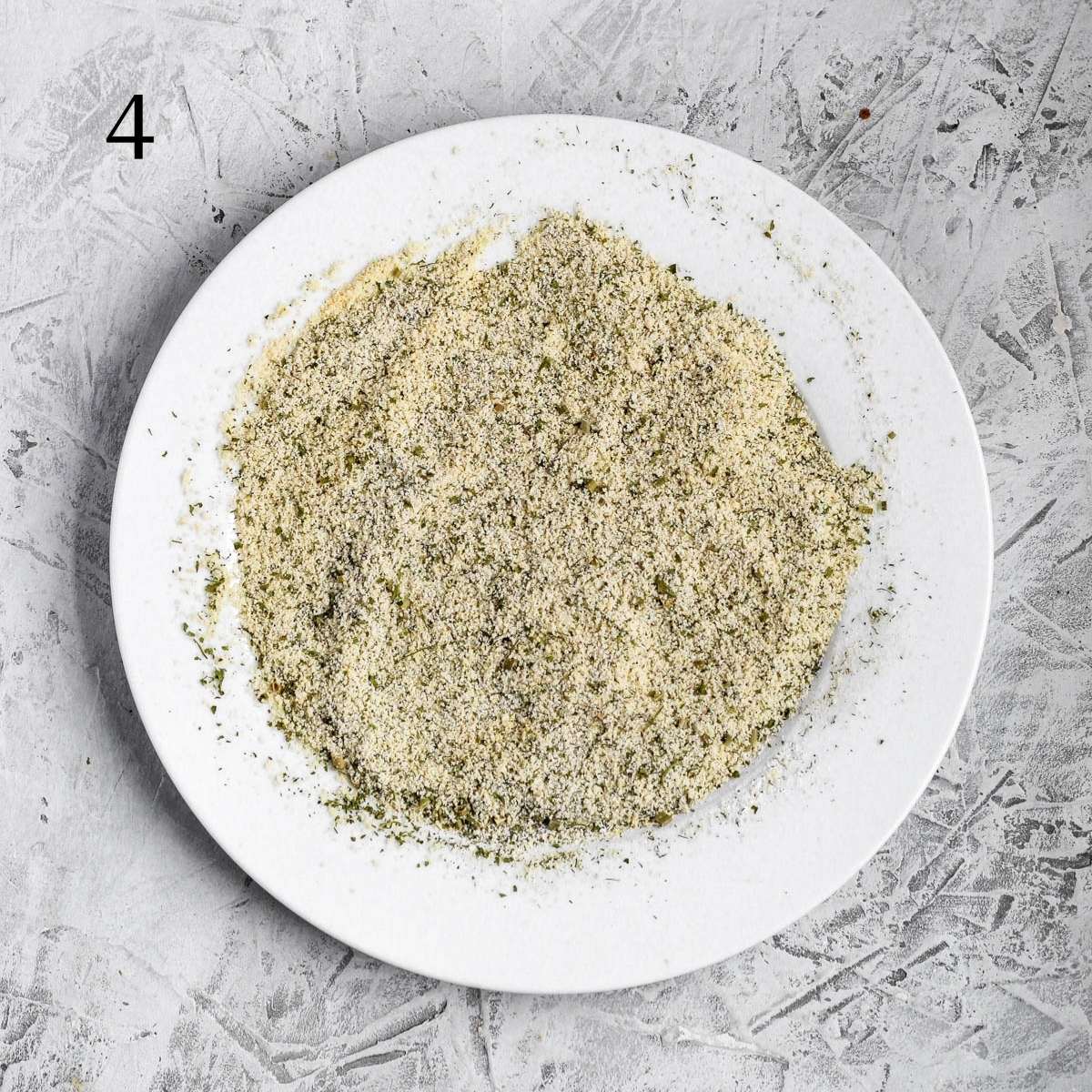 a plate with almond flour, parsley, garlic powder, onion powder, dill, chives, salt and pepper mixed together