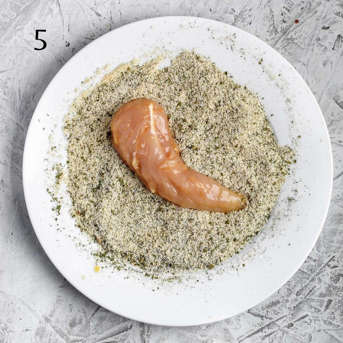 a almond flour mixture on a plate with a chicken tender on top