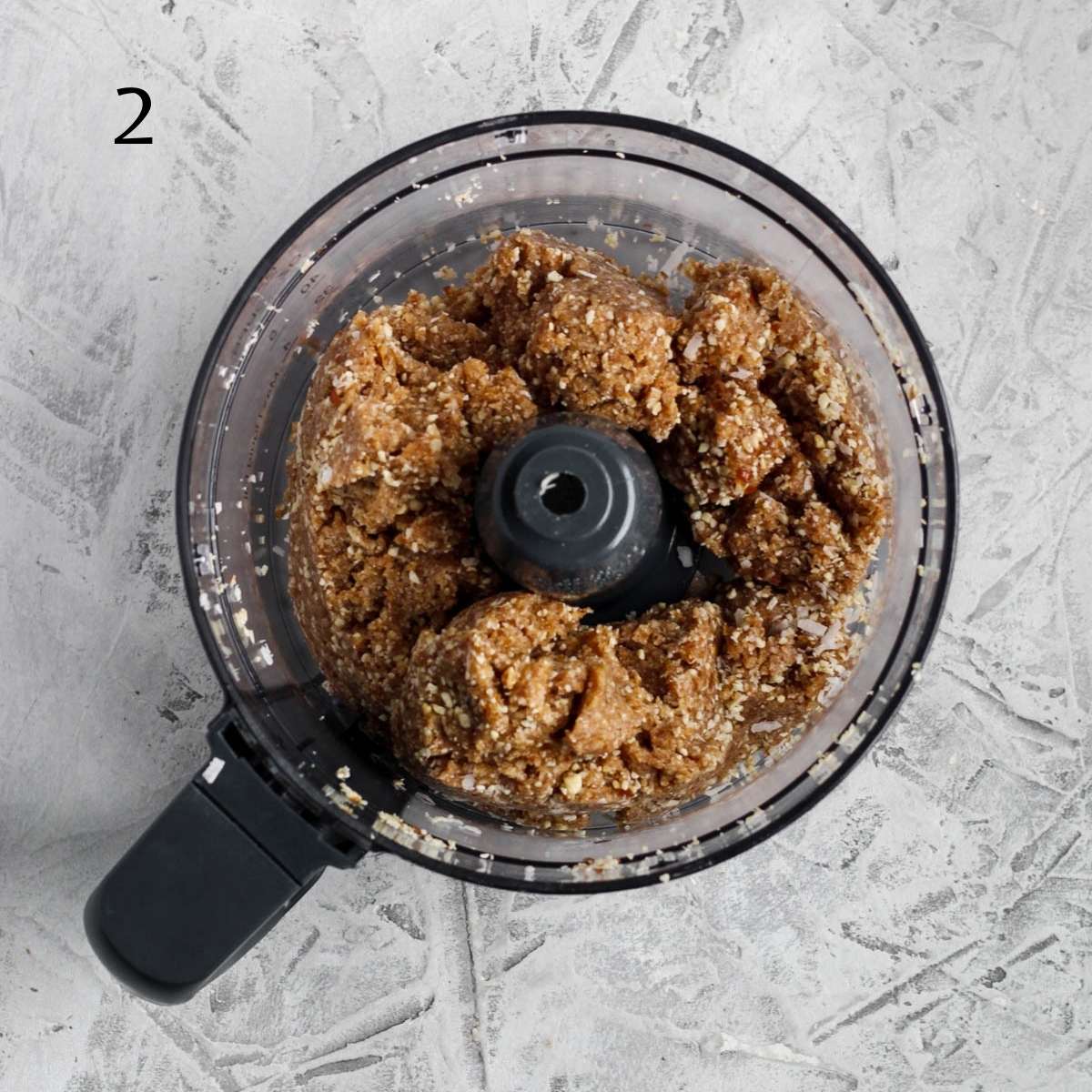 a food processor filled with healthy coconut ball mixture 