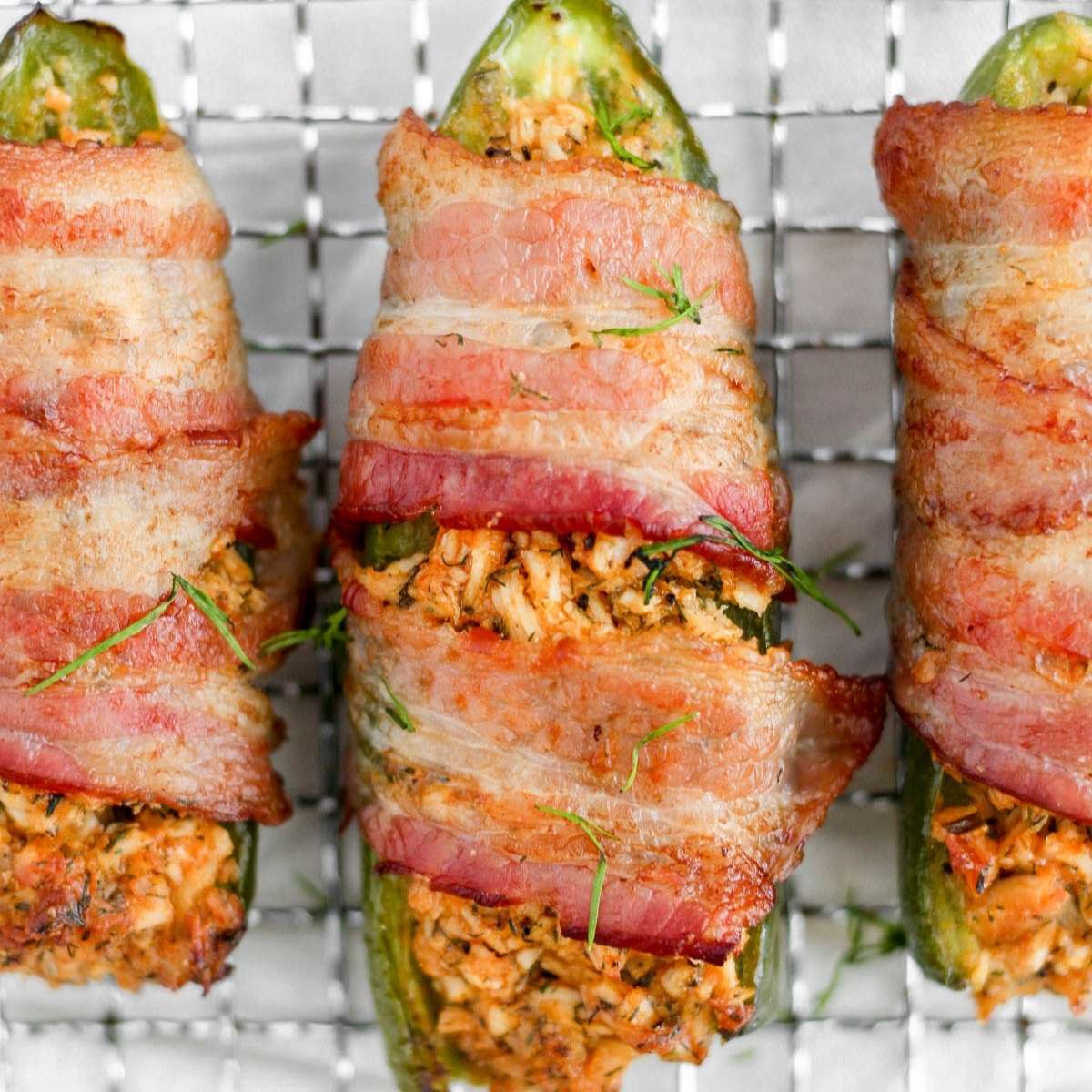 Buffalo chicken bacon wrapped jalapeno on a wired rack.