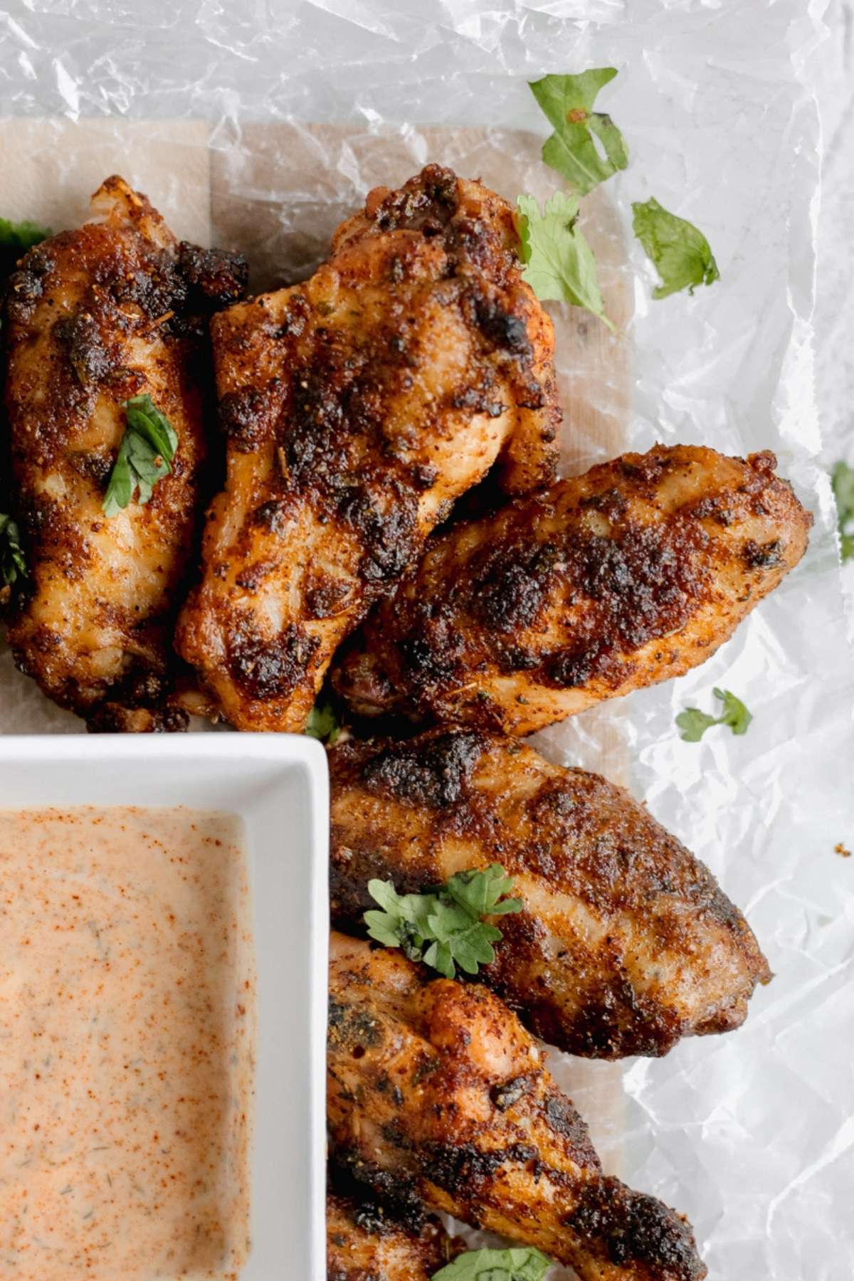 A tray of cilantro lime wings with chipotle ranch dipping sauce on the side.