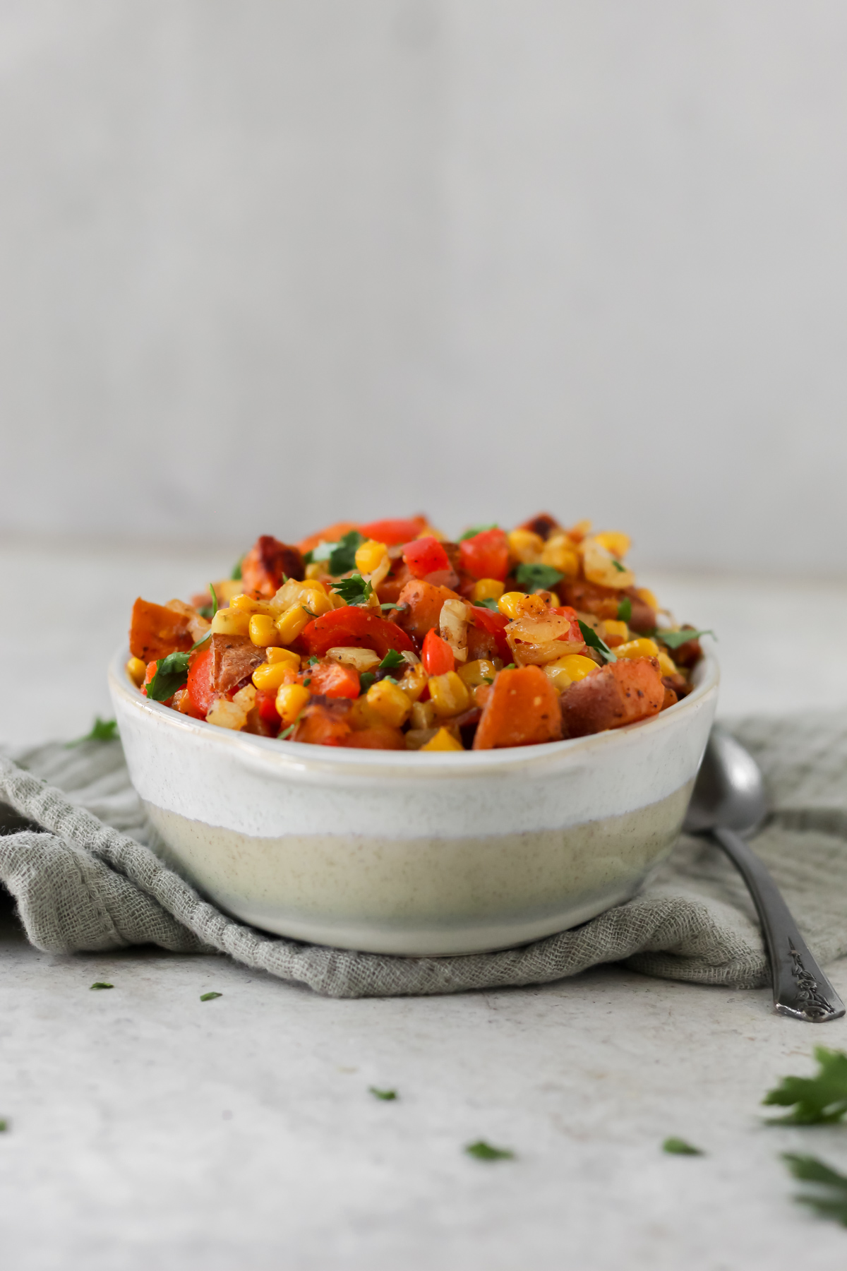 A bowl of sweet potato succotash sitting on a tea towel.