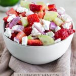 A Pinterest pin with a bowl filled with strawberry cucumber salad.