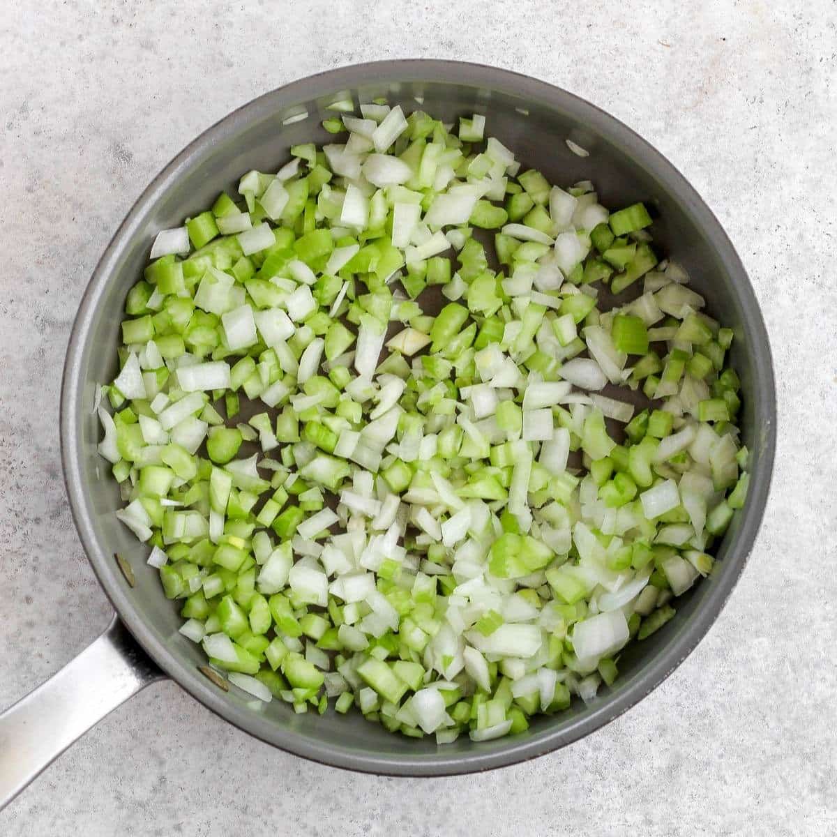 A pan filled with diced celery and onion.