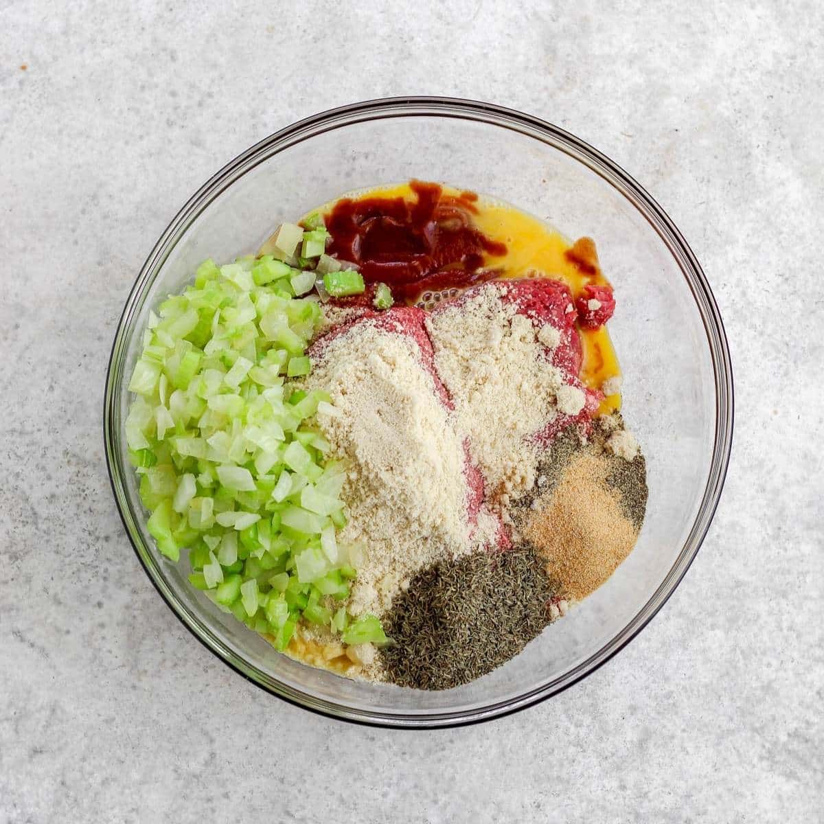 A glass bowl filled with whole30 meatloaf ingredients.