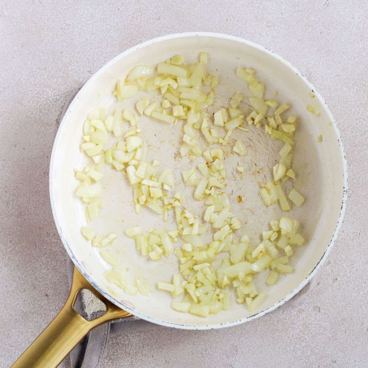 A pan with sautéed onions and garlic in it.