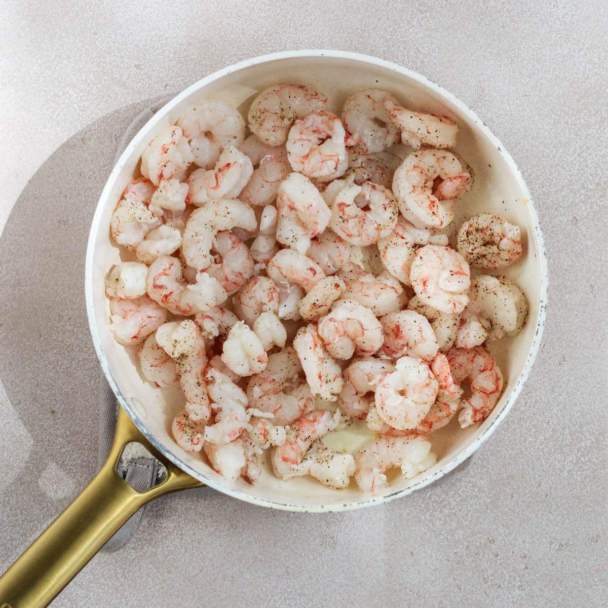 Raw shrimp inside of a large pan.