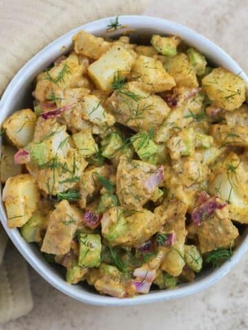 A white bowl filled with buffalo ranch potato salad.
