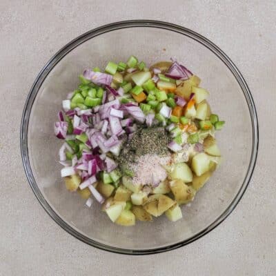A glass bowl filled with ingredients to make buffalo ranch potato salad.