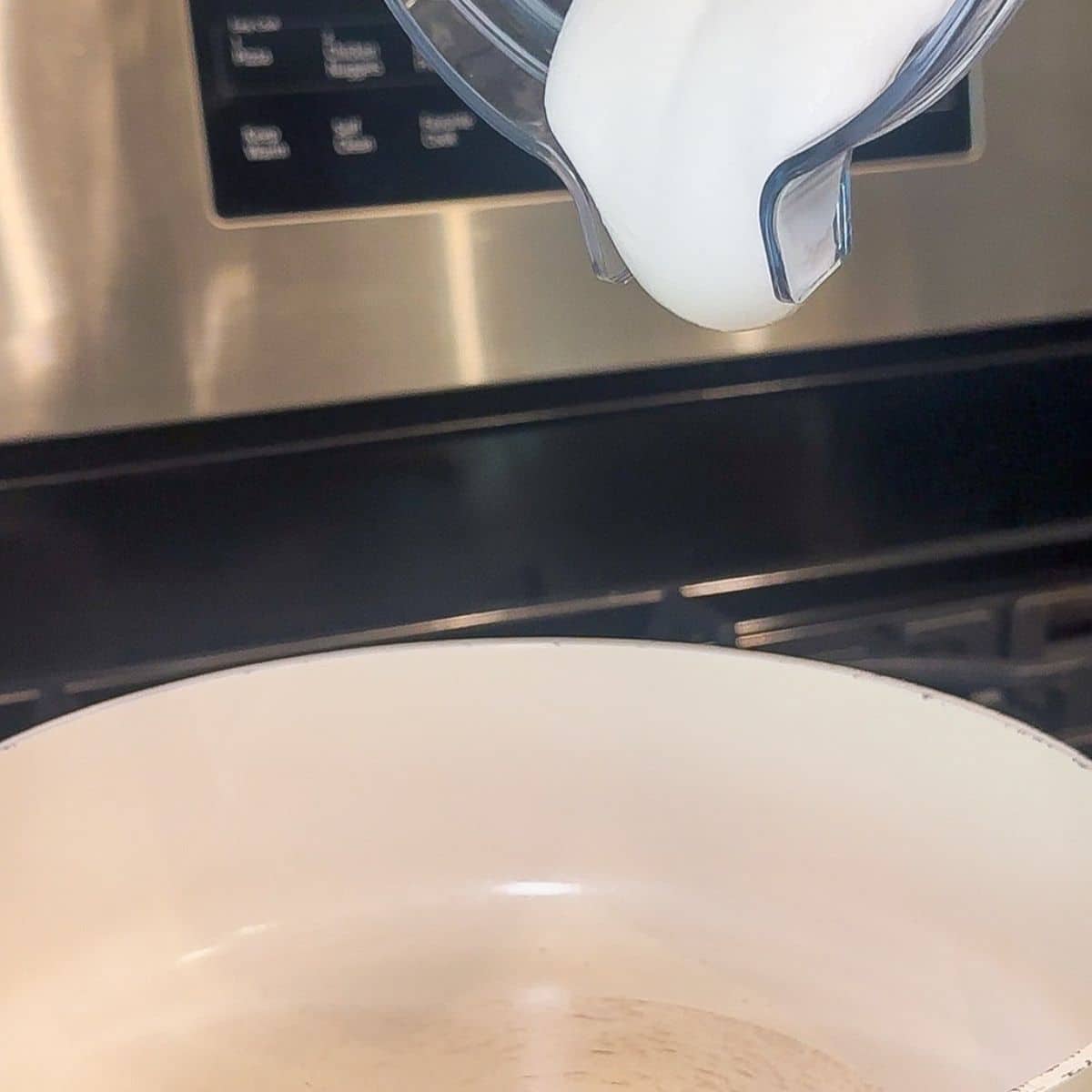 The blended cottage cheese and milk being poured into a skillet.